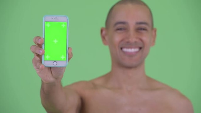 快乐的男人微笑着并显示带有绿色屏幕的电话
