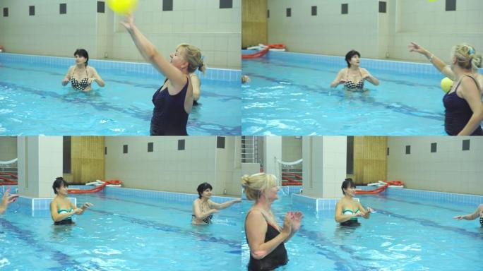 重要的资深女性在游泳池里打排球，作为一种在有氧运动开始前热身的方式
