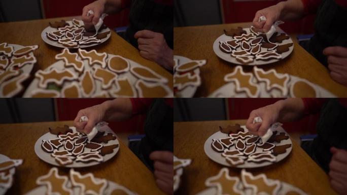 一位面目全非的老妇用糖粉和糕点袋装饰姜饼。圣诞姜饼，自制饼干，家庭传统