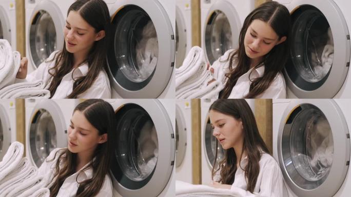 年轻的女士在洗衣店整理干净的毛巾