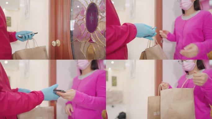 网购包装概念锁定期由于传染性疾病，送货员戴着蓝色手套，正在前门向年轻顾客运送盒子。