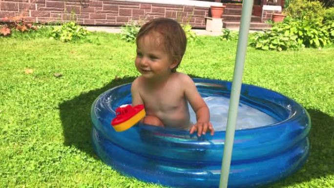 小男孩在后院的游泳池里玩得开心