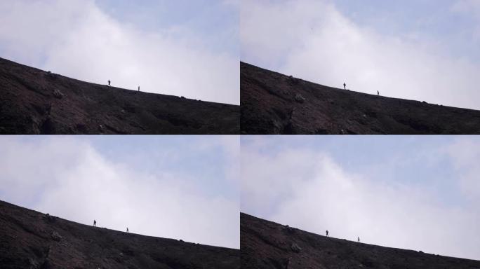 徒步旅行者在高空行走，看到西西里岛的埃特纳火山口