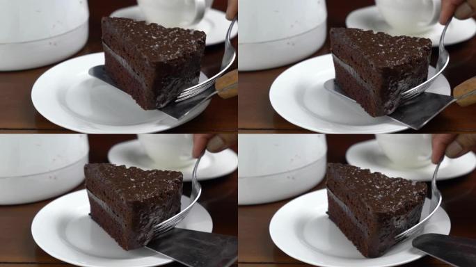 将一块巧克力蛋糕放在木制桌子上的白色陶瓷盘中。