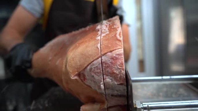 一位厨师用电锯锯生冻肉