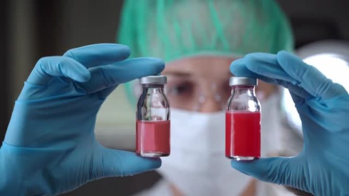 在实验室中进行重要的科学研究，以开发有效的抗冠状病毒感染疫苗。穿着防护服的女化学家拿着两个带有潜在疫