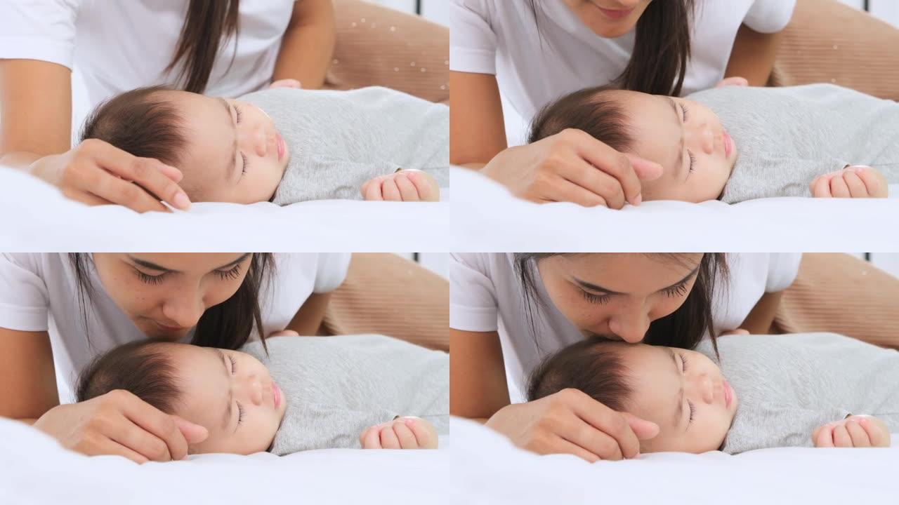 新生女婴7个月正在睡觉，母亲用爱与关怀亲吻婴儿的脸颊，慢动作拍摄。
