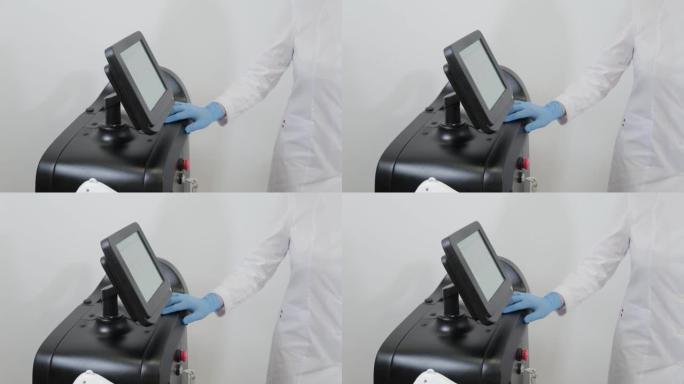 美容师戴手套的手在手术前打开激光设备，侧视图。概念美容中心，医疗诊所