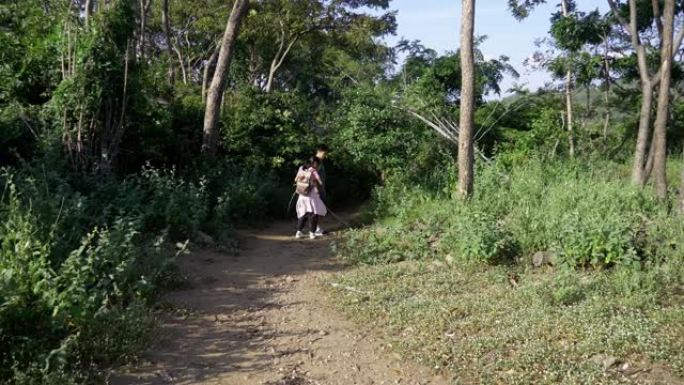 背包客的孩子们早晨带着阳光一起走进森林到山峰，积极的生活方式理念。