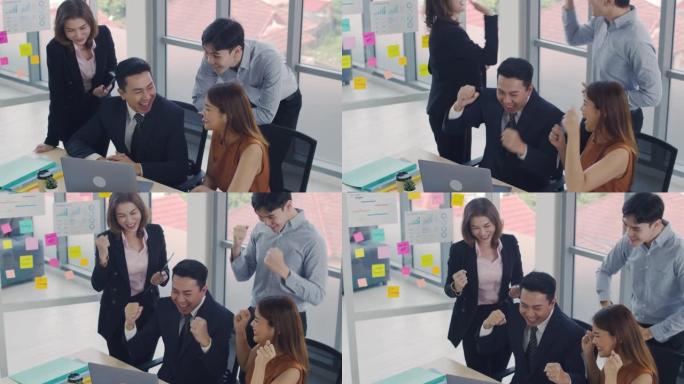 快乐成功的亚洲商业团队庆祝给予击掌。一群在办公室庆祝企业团结成功的企业。