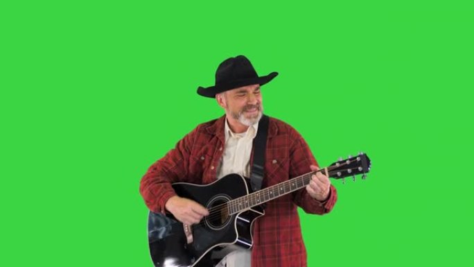 穿着图案衬衫的高级男子在绿色屏幕上唱歌和弹吉他，色键