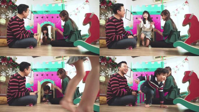 十几岁的女孩，男孩在玩圣诞节礼物，家用纸制玩具，来自成年父亲，母亲在度假12月，东南亚家庭一起在装饰
