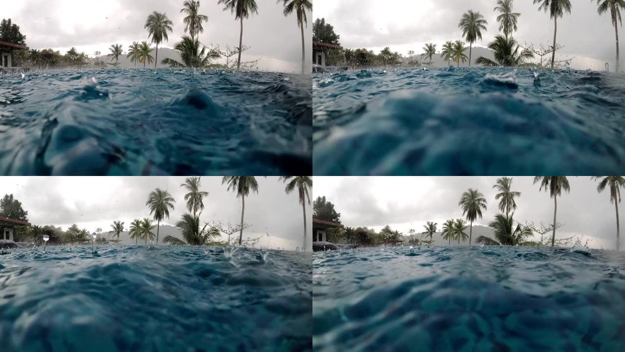 糟糕的假期概念。大雨落入海洋附近的豪华游泳池，背景是椰树。
