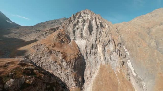 快速飞行运动frpv无人机电影拍摄山脚秋谷。蓝天背景下石质高地和山峰之间的航拍镜头河流