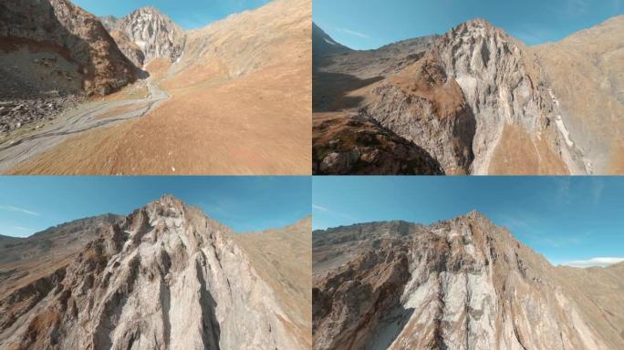 快速飞行运动frpv无人机电影拍摄山脚秋谷。蓝天背景下石质高地和山峰之间的航拍镜头河流