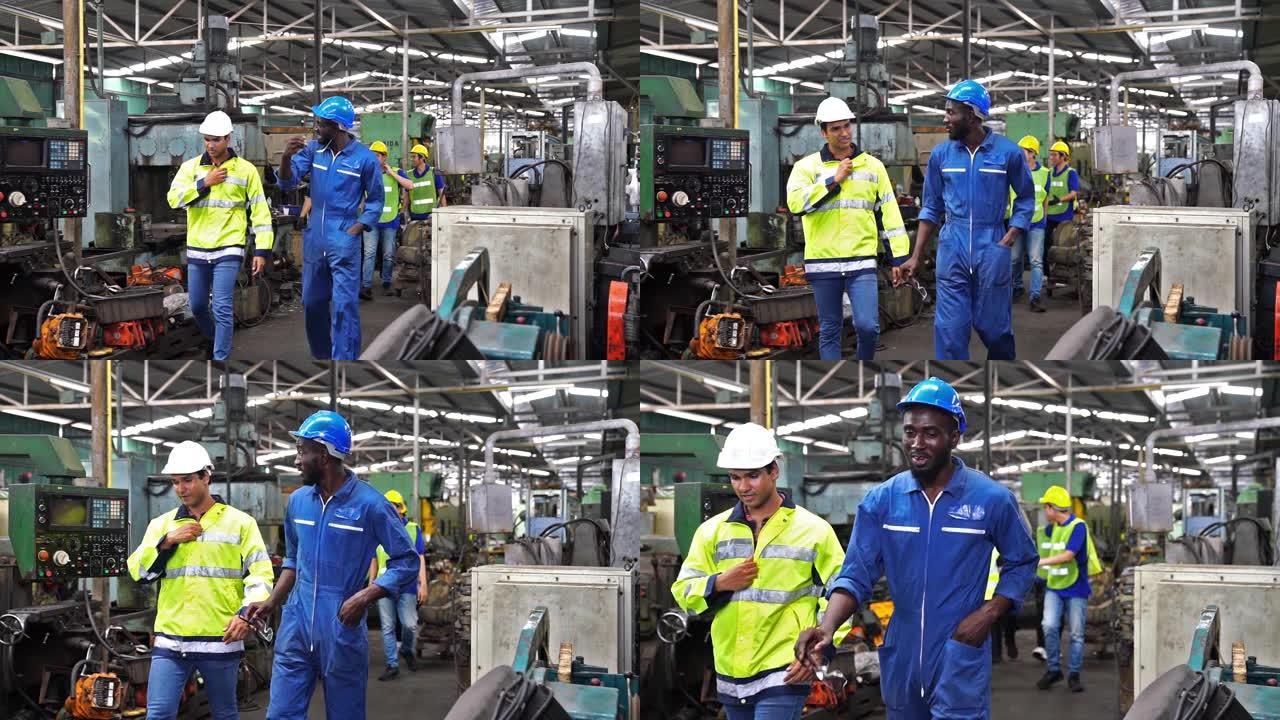 工程师和员工休息时走进工厂。工程师和工业工人正在研究大型机器。