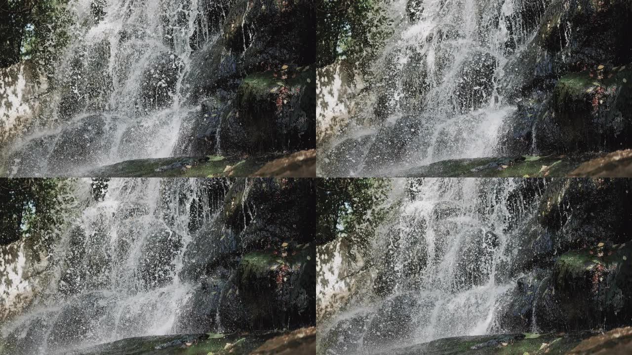 岩石上的瀑布，山中的瀑布，从倾泻的瀑布中飞溅。水倒在石头上。