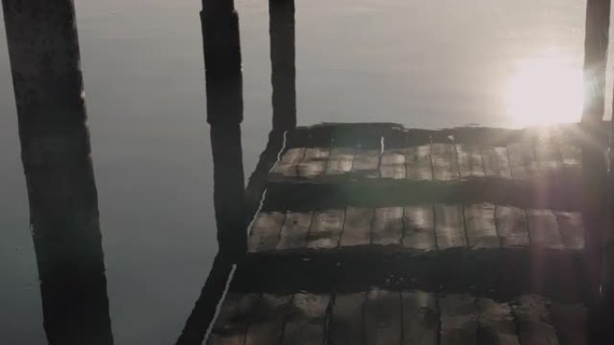 河流中阳光的倒影，湖边美丽的阳光，水上的木桥。