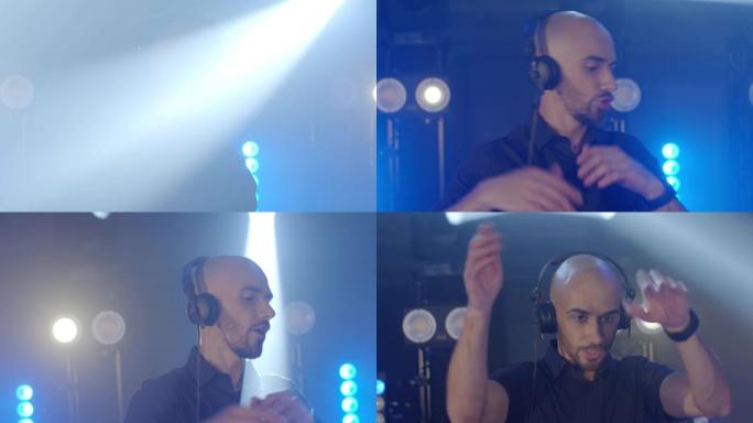 带耳机的精力充沛的秃头男子的现场DJ表演，在派对音乐会音乐家舞台上跳舞