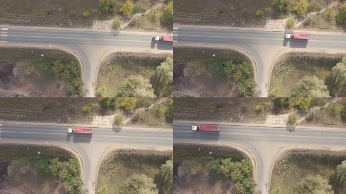 在具有交叉路口的柏油路路上经过的卡车的俯视图。