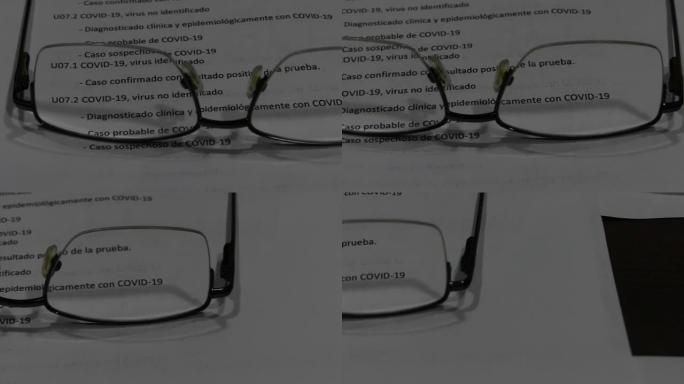 在桌子上的眼镜之间看到了covid 19报告的视频