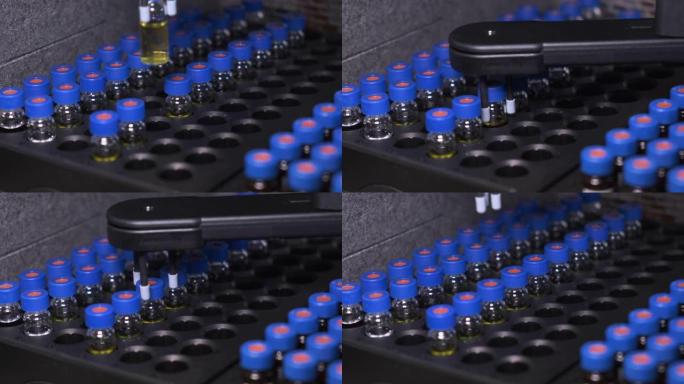 高效液相色谱系统自动取样器自动输送线。托盘中有蓝色瓶盖的小瓶。疫苗和药品的测试