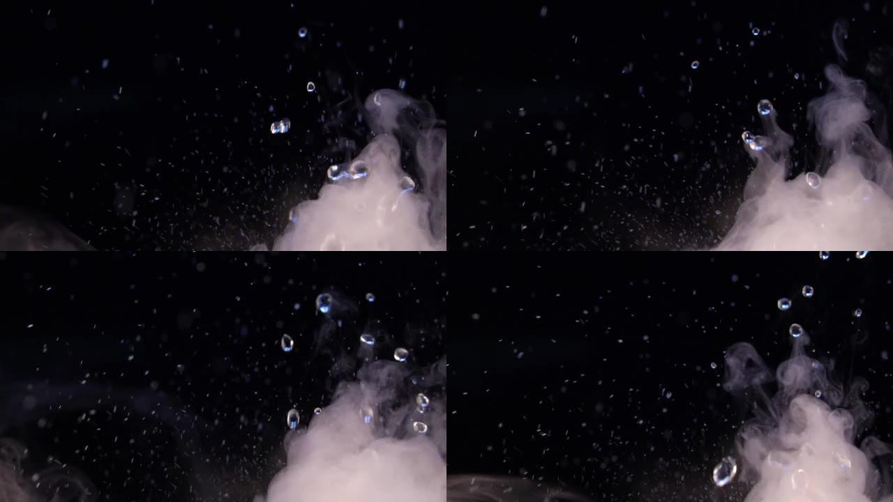 放松视频，在黑色背景上有飞溅和水滴，有雾或烟，具有循环功能。close-up.Swirl中的水飞溅和