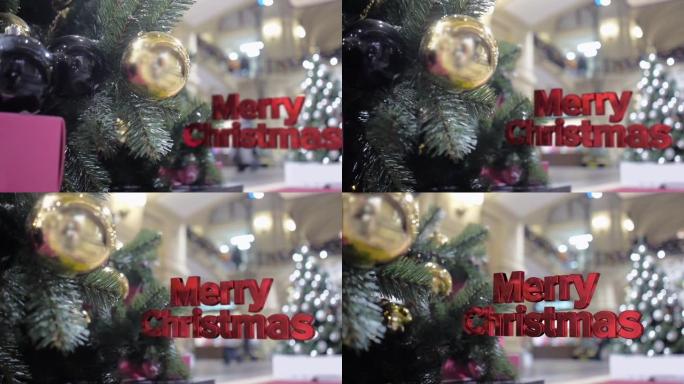 圣诞快乐的三维字母在装饰有金色和黑色球的圣诞树的背景下脱颖而出