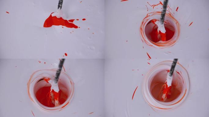 使用钻头上的搅拌器在桶中混合白色和红色油漆。慢动作