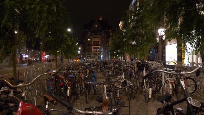 阿姆斯特丹市中心夜间照明著名中央街自行车停车场全景4k荷兰