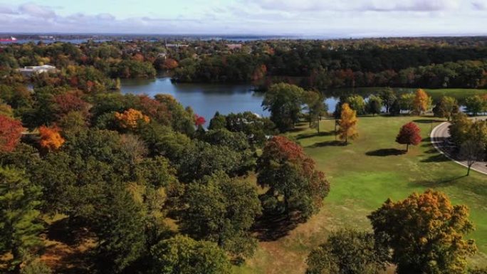 美丽的秋天空中飞越树木，朝着经典的白色大理石神庙，沿着罗德岛普罗维登斯的罗杰·威廉姆斯公园的湖边的音