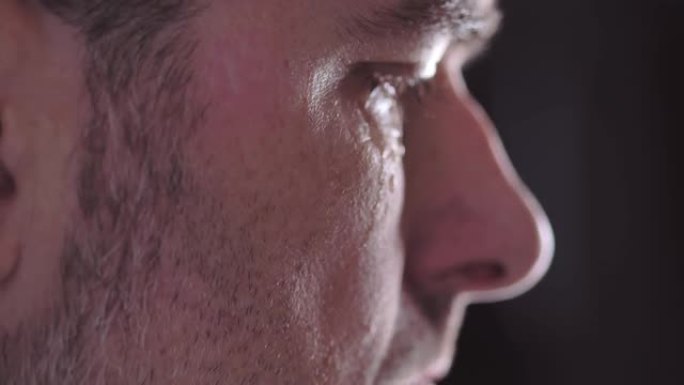 一个男人脸颊的特写镜头，眼泪滑下。