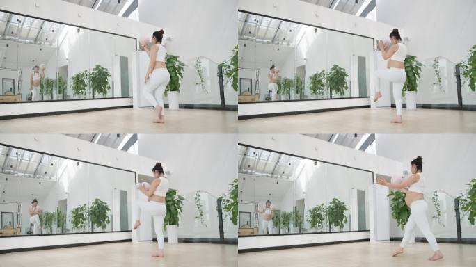 怀孕的现代女性在健身房锻炼身体练习瑜伽