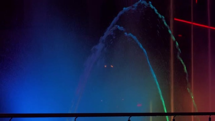 街边的喷泉夜晚有五颜六色的灯光，相机运动
