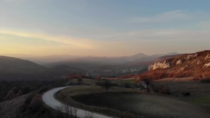 从山上飞来的无人机的航拍-越过山的道路，山的岩石景观