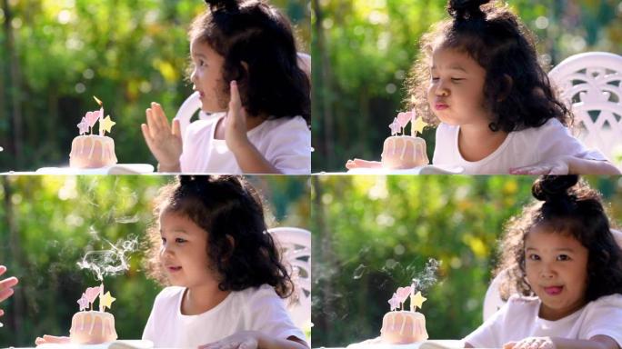 亚洲家庭生日派对快乐。可爱的小女孩的特写镜头用笑脸在小生日蛋糕上吹灭蜡烛。快乐小可爱女儿在家和爸爸妈