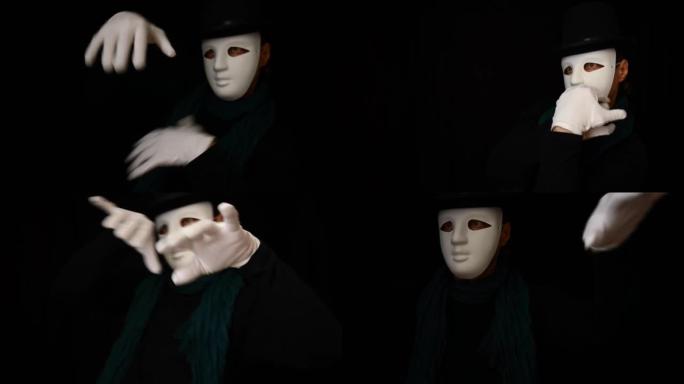 戴着白色面具的哑剧 -- 脸、帽子和白手套塑性跳舞，在黑色背景上表达感情。