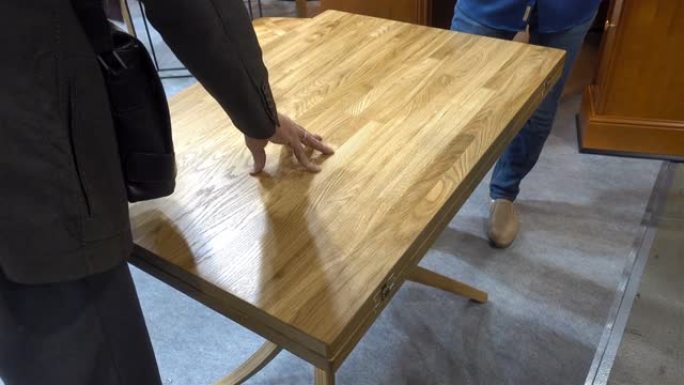 男人的手在4k中触摸木桌的表面