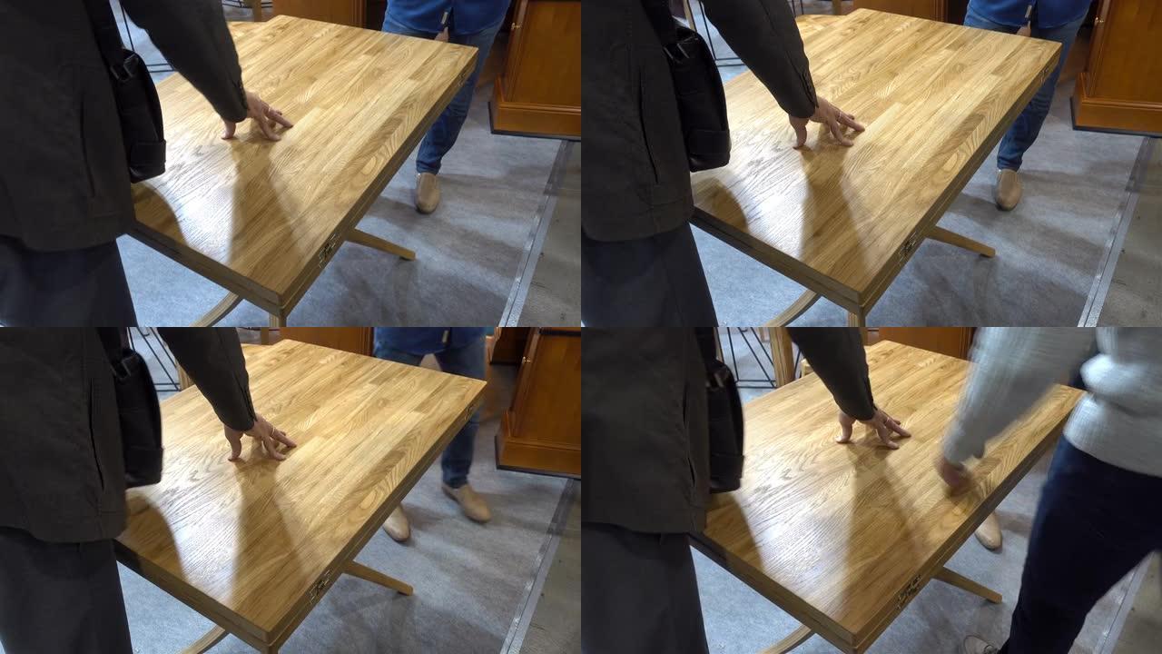 男人的手在4k中触摸木桌的表面