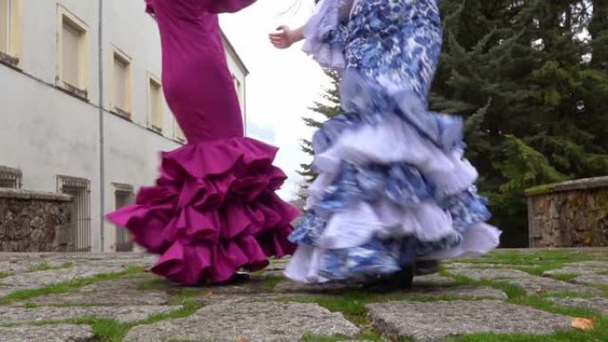 两个女人穿着典型的安达卢西亚弗拉门戈连衣裙跳舞。