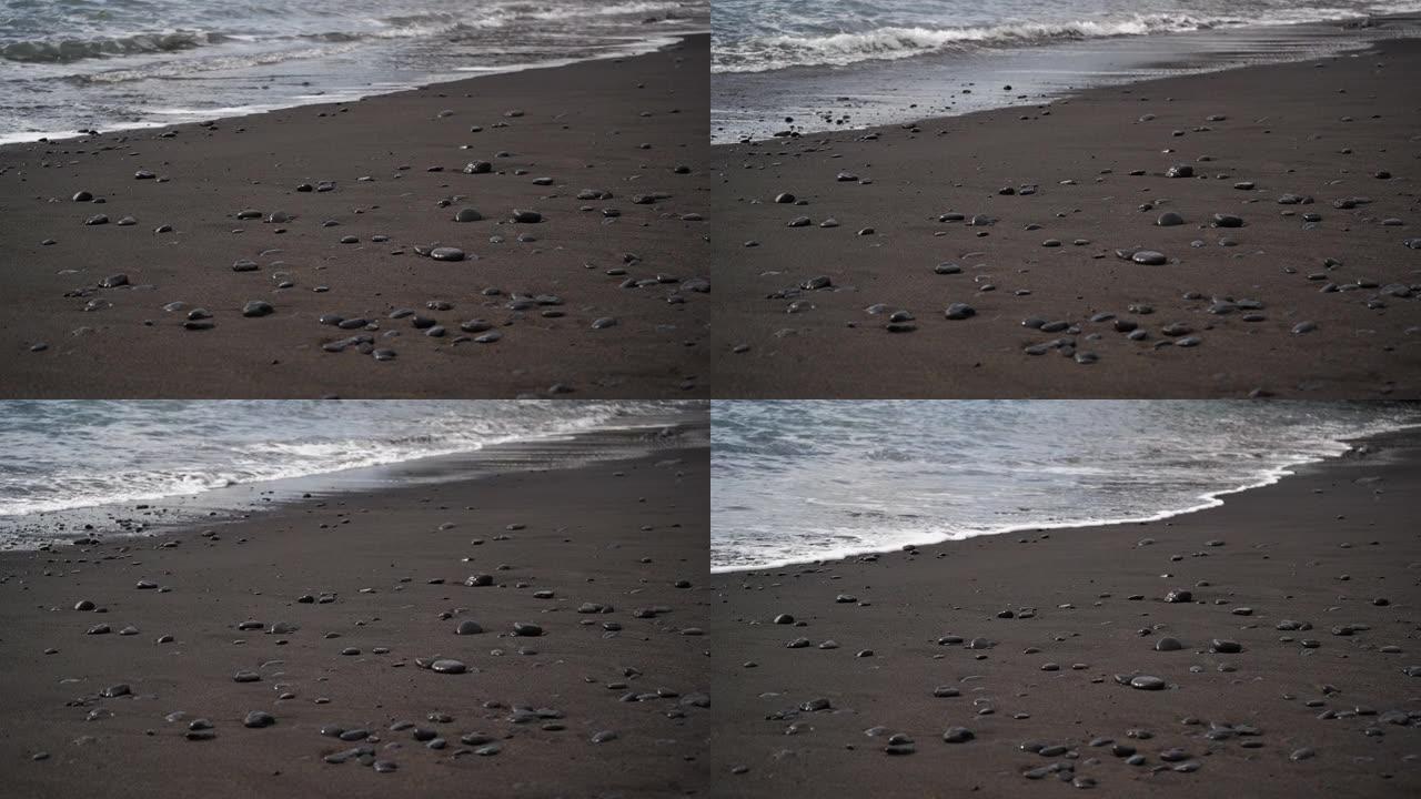 石头卵石躺在沙滩上的水浪和海洋泡沫