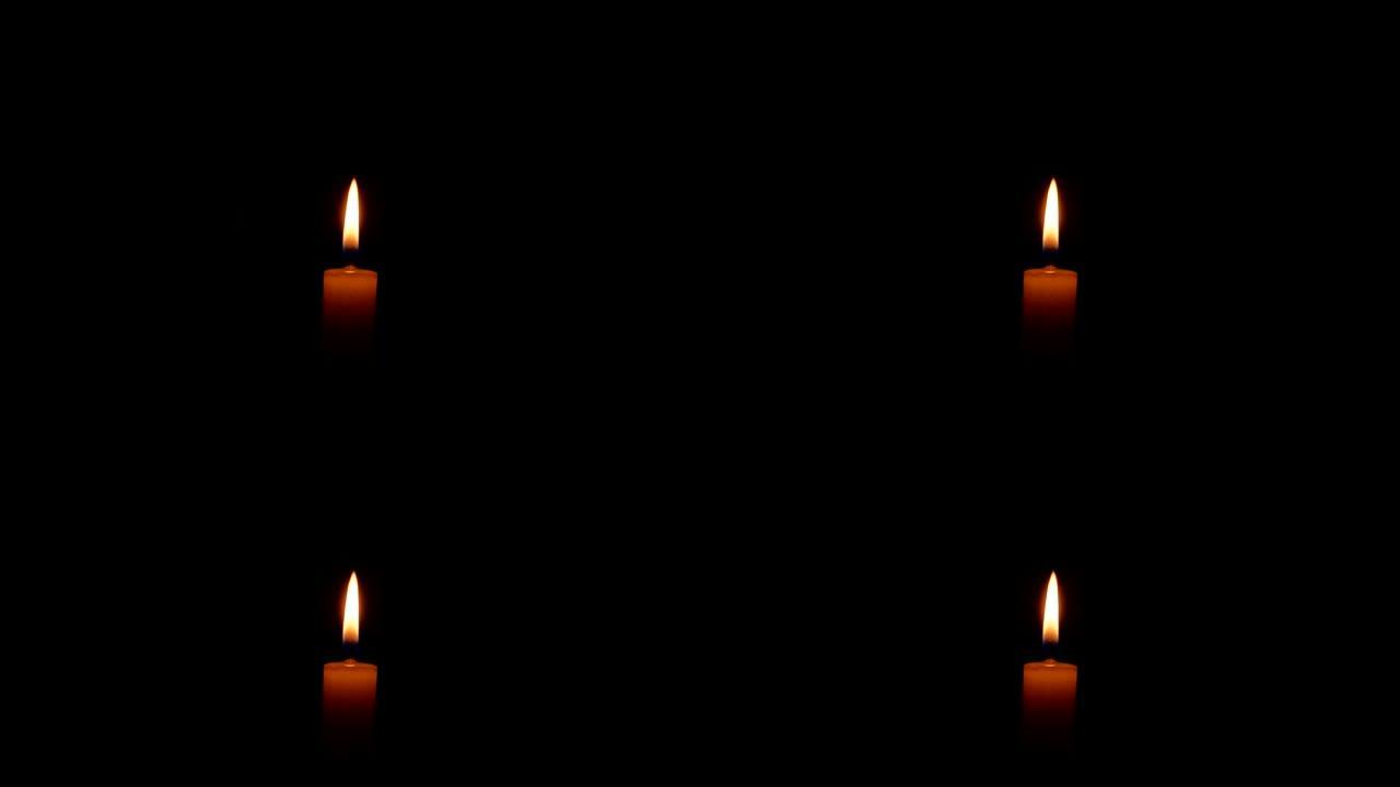 黑暗中燃烧的蜡蜡烛的火焰。蜡烛火的火焰。黑暗中的火。纪念日。沉默一分钟。葬礼服务。阵亡将士纪念日的灾