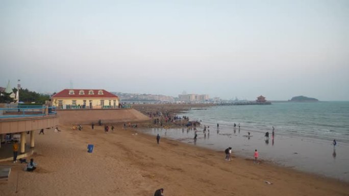 日落天空青岛市海岸线著名拥挤公共海滩全景4k中国