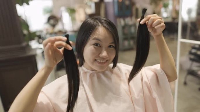 日本妇女在美发沙龙中展示自己的头发以捐赠