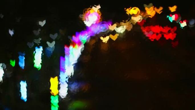 窗外的雨水浪在玻璃地板上，街道上的心形彩虹灯反射在
