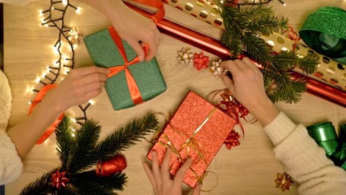 两个女人的手仔细包装圣诞礼物。节礼日