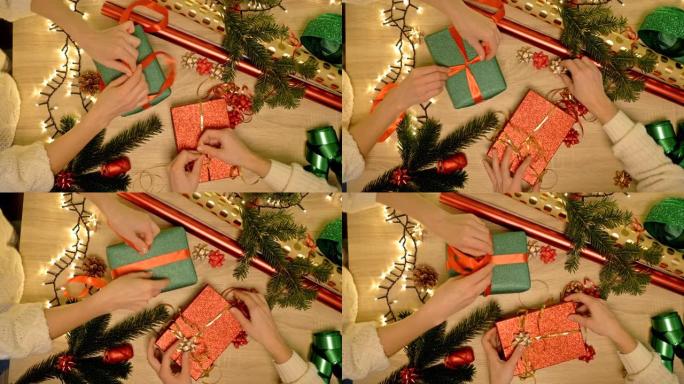 两个女人的手仔细包装圣诞礼物。节礼日