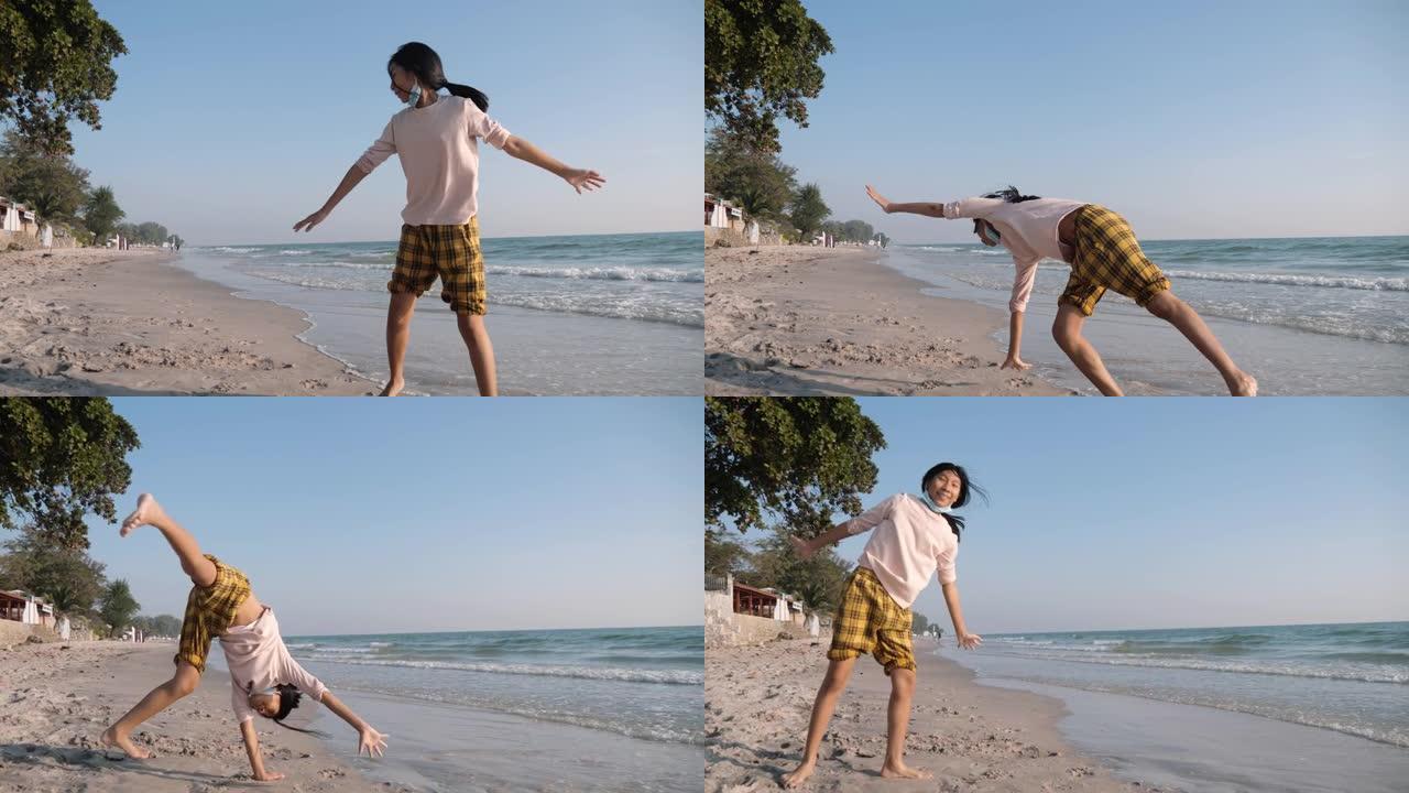 快乐的亚洲女孩早上在海滩上做翻筋斗，与家人一起度假，生活方式理念。