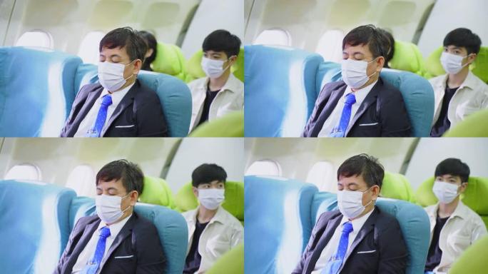 亚洲商人戴着口罩坐在飞机上的商务舱上。所有人都知道冠状病毒大流行。防止飞机上的Covid感染的新的正