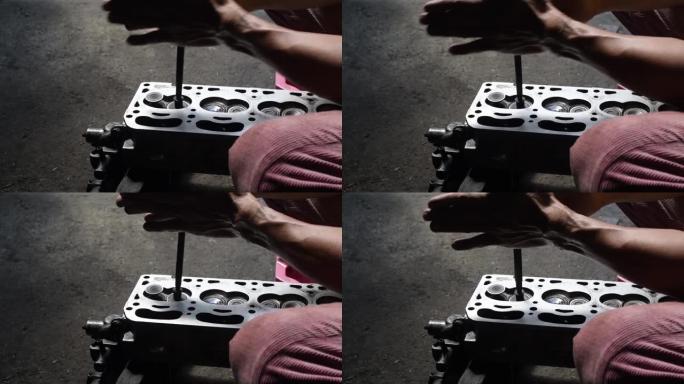 汽车发动机修理技师将研磨阀放入发动机缸体